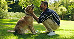 Man, dog and kiss with love in nature for walk, run or game of fetch break at outdoor park. Male person, owner and pet or Labrador animal with touch for reward, support or care in forest for training