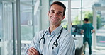 Face, doctor and happy man in hospital with confidence for healthcare service, medicine and wellness. Medical professional, cardiologist and portrait of worker, coworking and arms crossed in clinic