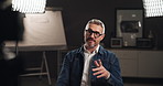 Talking, interview and man on set with camera for filming with documentary, show or movie in studio. Record, discussion and journalist by lights for TV public speaking with production equipment.