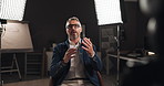Talking, interview and man by lights on set for filming with documentary, show or movie in studio. Recording, discussion and male journalist for television public speaking with production equipment.