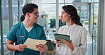Doctors, woman and man with tablet, documents and discussion for solution, review or info at clinic. People, surgeon and talking with touchscreen, application and happy for medical report at hospital