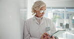 Healthcare, scientist and mature woman with tablet, serious and reading of medical research or online. Digital, biotechnology and person with glasses for info, pharmaceutical and review on website