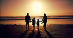 Family, silhouette and holding hands at beach sunset of summer vacation, travel trip and bonding together. Back, parents and children walk on ocean for tropical holiday, weekend journey and adventure