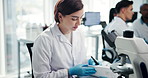 Science, lab and woman with microscope and notes for research, medical study and medicine discovery. Healthcare, pharmaceutical and scientist with equipment for vaccine, microbiology and experiment