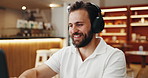 Headphones, typing and man in coffee shop for freelance creative career with online magazine. Audio tech, laptop and male journalist listening to podcast, music or radio in cafe for remote work.