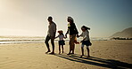 Family, kids and walk by holding hands at beach for summer vacation, travel trip and bonding together. Parents, children and security on ocean of holiday getaway, weekend journey and nature adventure