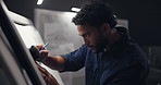 Drawing, night and man in studio for creative project with deadline for startup business visual communication. Sketching, art and male graphic designer sketching with branding prototype in office.