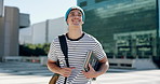 Happy man, student and walking with book in city for learning journey, education or scholarship. Male person, academic or young learner with smile or bag for local commute to school in an urban town