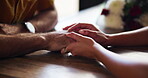 Couple, table and holding hands for care in relationship, support and affection for bonding. Apartment, touch and security in connection, marriage partnership and fingers for dating romance in home