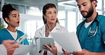 Doctors, team and discussion with documents in hallway with leader, report and tablet for medical solution. People, men and women with group, touchscreen and planning strategy for surgery at hospital