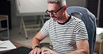 Typing, creative and man with computer, glasses and copywriter with ideas for project and article. Business, copywriting and mature person with tech for blog, contemplating and thoughtful for task