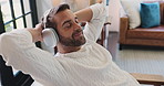 Relax, home and man with headphones, music and break with audio in living room and comfortable. House, resting and person with tech for streaming, listening and playlist for chilling in lounge