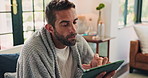Tablet, telehealth and thermometer with man on sofa in living room of home for remote work. Healthcare, medical and search with sick person in apartment to measure temperature for fever or symptoms
