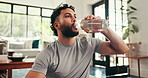 Man, drinking water and fitness on floor in home with rest, perspective and hydration for wellness in morning. Person, bottle and liquid for detox, gut health and break with exercise at apartment