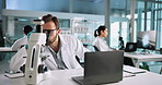 Microscope, scientist and man with chemical in beaker for medical experiment in lab with laptop at night. Chemistry, biotechnology and science with sample in glass for research or cure development