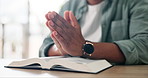 Prayer, hands and man with bible in apartment for religion study, worship or spiritual journey. Hope, gratitude and male person with scripture praying for peace, faith or guidance in living room.