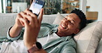 Dating app, phone and relax with man on sofa in living room of home for communication. Contact, relax and social media with happy person in apartment for connection, notification or online chat
