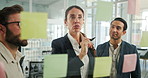 Business people, sticky note and writing on glass wall, planning and mind map with problem solving at tech startup. Woman, leader and group by board with review, feedback and solution at company