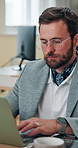 Business, man and typing on laptop in office for financial report and company payroll system. Bookkeeper, employee and digital review of finance records, data entry and tracking budget performance