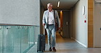 Suitcase, walking and mature man travel for business, conference and industry workshop. Convention center, journey and entrepreneur person in hotel lobby for seminar, corporate pride and career trip