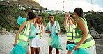 Celebration, high five and waste with friends on beach for cleaning, conservation or environmentalism. Activism, charity and rubbish with happy people on coast for achievement, teamwork or success