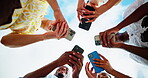 Outdoor, group and friends with hands for mobile, typing and connection for social media in circle. Blue sky, people and network with smartphone for application, digital and technology in low angle