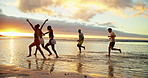 Holiday, sunset and friends running on ocean water for adventure, fun and bonding together with energy. People, sea race and group on trip outdoor at beach for summer vacation, travel and freedom