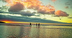 Running, friends and people on beach at sunset for holiday, vacation and weekend together. Nature, travel and men and women in ocean, sea and waves for adventure, freedom and relaxing outdoors