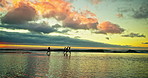 Running, sunset and shadow of friends on beach for holiday, vacation and weekend together. Nature, travel and men and women in ocean, sea and waves for adventure, freedom and relaxing outdoors