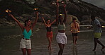 Happy, friends and dancing with sparkler on beach for ocean party, travel reunion and bonding together. Group, people and fireworks with rhythm movement, holiday celebration and nightlife for getaway