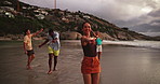 Beach, travel and friends with vacation, sparklers and celebration with tropical island. Happy people, seaside and group with nature, water and summer holiday with social event, dance and Zanzibar