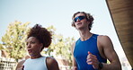 Running, workout and interracial couple in town for cardio, exercise and marathon training. Low angle, fitness and young man with woman for endurance, love and health with runner on road with energy