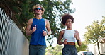 Fitness, exercise and interracial couple in town for cardio, workout and marathon training. Low angle, running and young man with woman for endurance, love and health with runner on road with energy