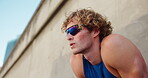 Outdoor, man and tired with thinking for fitness, marathon challenge and breathing on break by below. Wall, male person and runner with rest for exercise, exhausted or fatigue with sunglasses in city