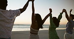 Holding hands, beach and people with sunset, group and celebration with summer holiday. Seaside, nature and friends with weekend break, ocean and cheering with reunion, horizon or support in Zanzibar