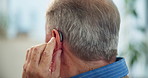 Home, back or senior man with hearing aid, technology for ear or wellness. Pensioner, old person with disability or healthcare with listening device, retirement or audio medical help or sound implant