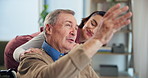 Woman, caregiver and person with disability, pointing and senior care for patient, talking and wheelchair. Healthcare, medical professional and rehabilitation in clinic with nurse and assisted living