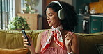 Music, dance and woman with phone on sofa for streaming video, subscription and multimedia. Headphones, audio technology and happy African person listening to radio, sound and album online in home
