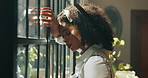 African woman, window and stress in home with headache, mistake or regret with reflection for decision. Person, sad and thinking with perspective, loss or grief with mental health in morning at house