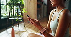 Hands, home and woman with smartphone, fitness and smile with social media, texting and internet. Apartment, closeup and happy person in lounge, cellphone and mobile user with app to track progress
