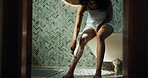 Bathroom, shaving legs and African woman for cleaning, wellness and grooming in home. Morning, beauty and person with razor, foam and cosmetics for epilation, hair removal and hygiene for smooth skin