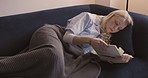 Older woman retirement, reading book and living room sofa, couch and apartment, peace and book club hobby in Australia. Aged female relax lifestyle, literature and story books in home lounge