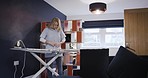 Woman, nurse iron clothes or uniform, dressing for work in morning in her home while getting ready. Mature lady cleaning, doing chores with ironing board and shirt or laundry for routine service