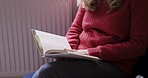 Book, reading and relax with a woman enjoying a story or literature while sitting on a chair in her home. Books, morning and lifestyle with a young female turning pages of a novel to enjoy a hobby