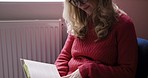 Learning, reading and woman with book to relax in home  with the bible, poetry or story for wellness. Reading book, knowledge and focus of literature girl with glasses thoughtful on word analysis.

