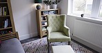 Living room, house and furniture in room for luxury and comfort for real estate, interior design or renovation mockup. Hotel, hospitality and show house background with chair, window and bookshelf