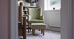 Furniture, luxury interior and chair in the bedroom of modern apartment or house with accessories. Stylish, home decor and room with a classic armchair, plants and bookshelf for decoration in a home.