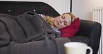 Sleep, relax and a woman on sofa with blanket living room, rest and relaxing nap time. Tired, exhausted and warm cozy sleeping after work or housework on couch at home in apartment on winter evening.