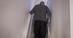 Senior injury man, stairs crutch walking or tired disabled elderly holding railing for balance in home. Disability retirement, medical physiotherapy equipment and rehabilitation exercise in house