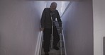 Disability, crutches and senior man on the stairs after an accident or medical injury in a house. Elderly man walking on steps for exercise of muscle for health during the rehabilitation of body